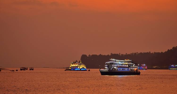 Bateaux illuminés sur une rivière au coucher du soleil