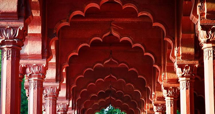 Arches en grès rouge dans un bâtiment historique.