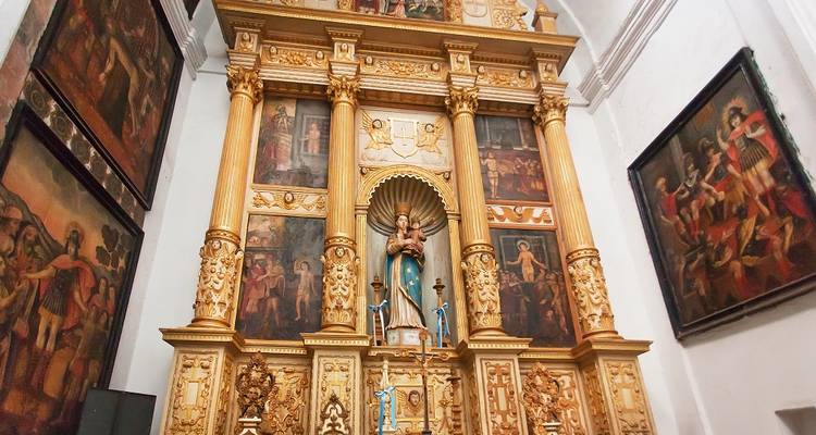 Intérieur d'une église avec des autels ornés et des peintures.