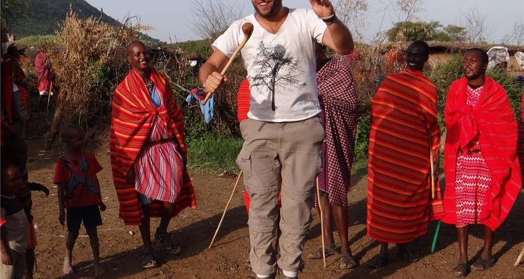 Les voyageurs se joignent aux habitants maasaï dans une cérémonie de danse joyeuse avec des sauts sur le sol poussiéreux du village.