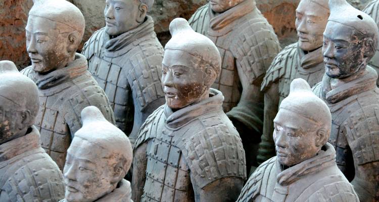 Rangée de Guerriers en Terre Cuite de taille naturelle debout dans des fosses en terre à Xi'an.