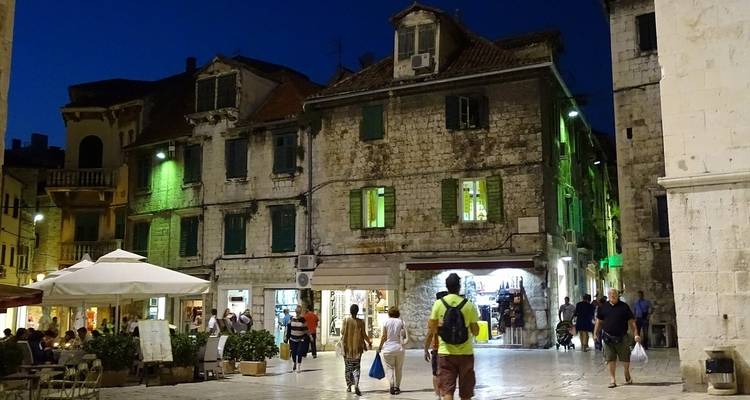 Una escena callejera animada con arquitectura colorida por la noche.