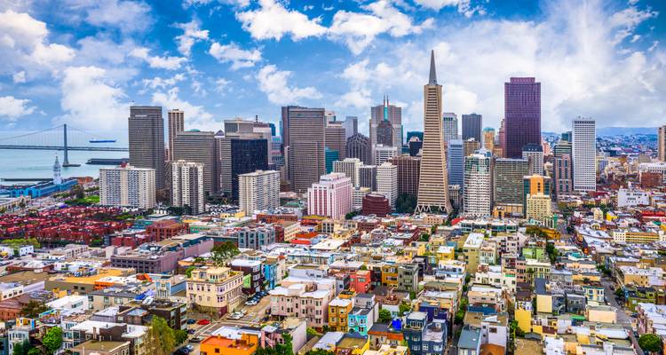 Luftpanorama der Innenstadt von San Francisco mit Transamerica Pyramid und Bay Bridge unter hellen Wolken.