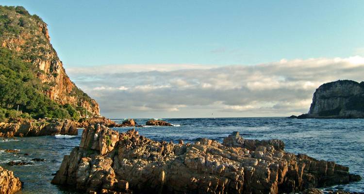 Rugged coastline with rocky formations and open sea.