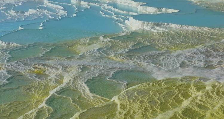 The travertine terraces at Pamukkale with clear blue waters.