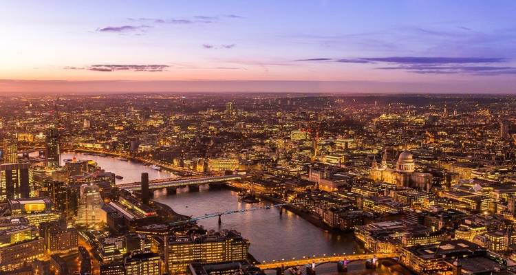 Una vista aérea del paisaje urbano de Londres iluminado al anochecer.