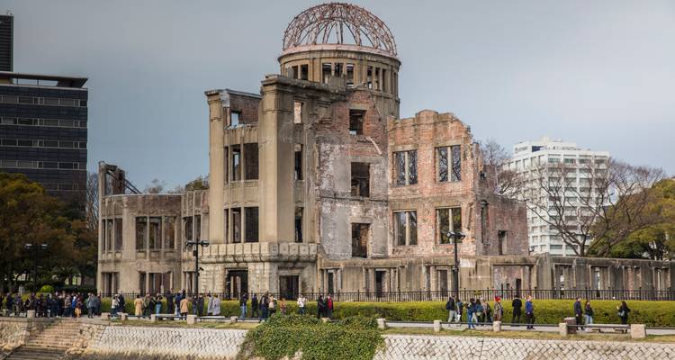 Le Dôme du Bomb Atomique préservé sur les rives d'Hiroshima avec des visiteurs rendant hommage ci-dessous.