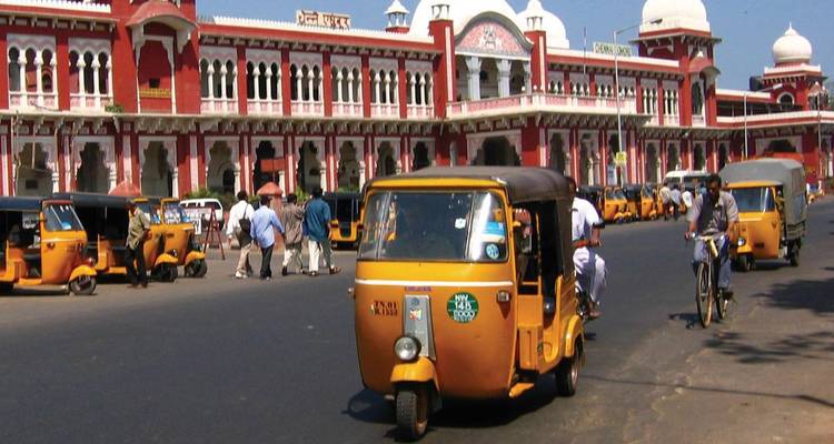 Auto-rickshaws and commuters outside the red-and-white Victorian railway station in Chennai.