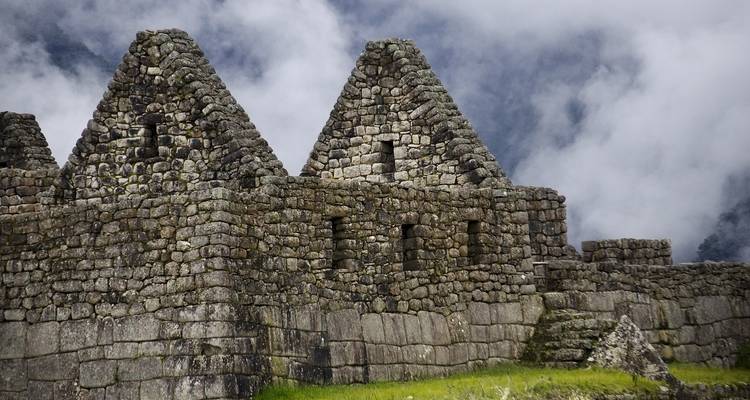 Primer plano de antiguas estructuras de piedra contra un cielo nublado.