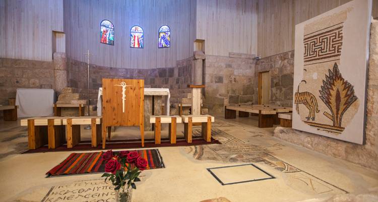Simple church interior on Mount Nebo with mosaic floor and small altar.