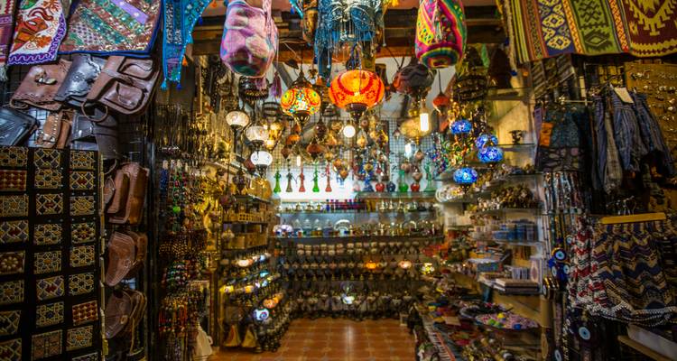 Kleurrijk, met lantaarns verlicht interieur van een Noord-Afrikaanse ambachtswinkel vol met textiel en kleine souvenirs.
