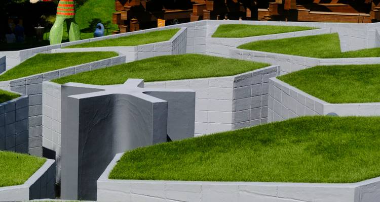 Jardin géométrique avec des allées d'herbe verte.