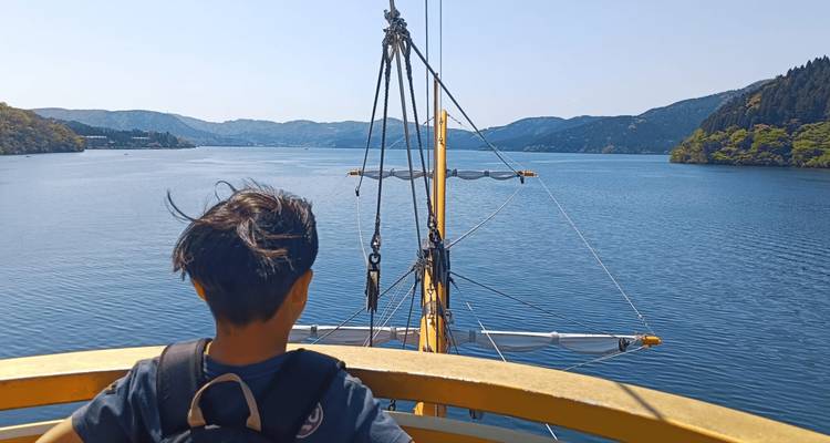 Personne sur un bateau profitant d'une vue panoramique sur le lac.