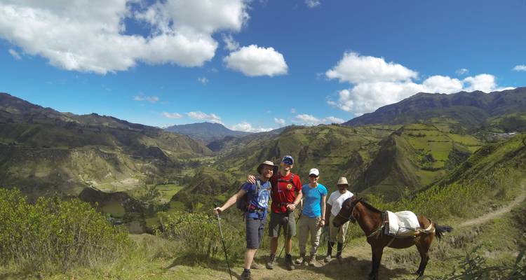 Gruppe von Menschen und ein Pferd mit Blick über ein Tal.