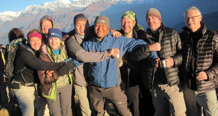 Grupo de excursionistas posando juntos con montañas de fondo