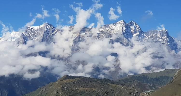 Wolken, die über schneebedeckten Berggipfeln schweben.