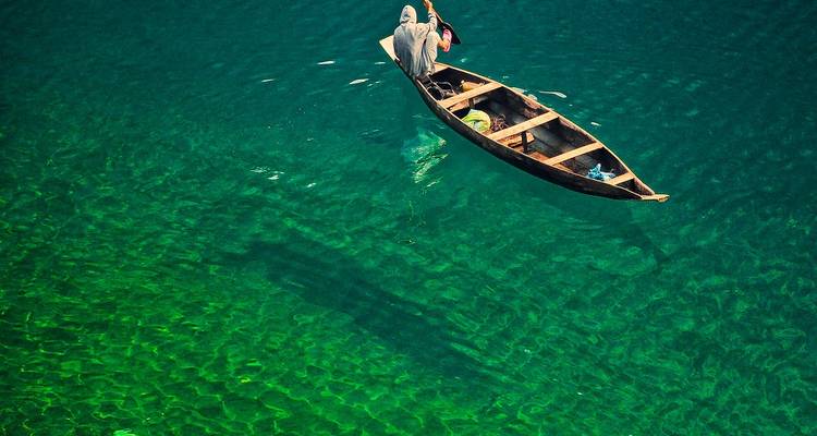 Luchtfoto van een boot op helder groen water.