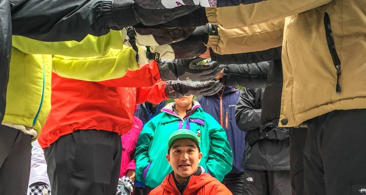 Eine Gruppe von Menschen in Winterkleidung bildet mit ihren Armen einen Tunnel.