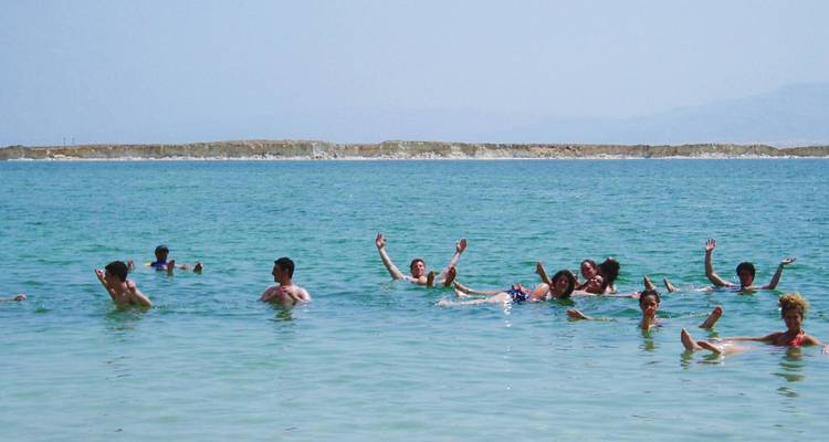 Groep mensen drijvend in een groot waterlichaam, waarschijnlijk een zoutmeer.
