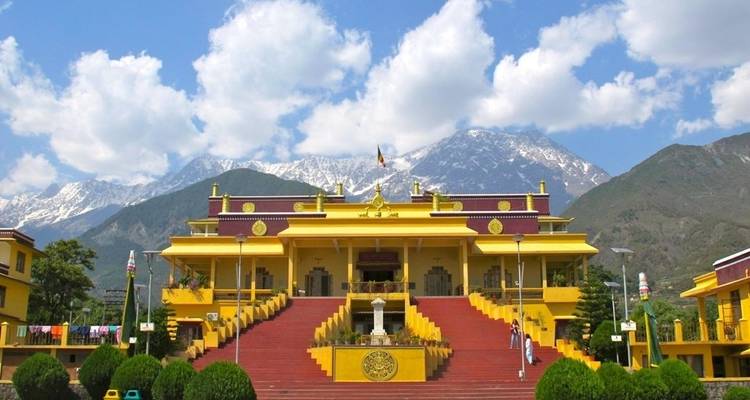 Gele tempel met bergen op de achtergrond.