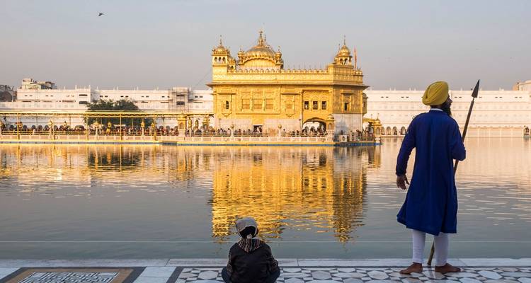 Gouden Tempel met mensen bij het water, één in een blauw gewaad.