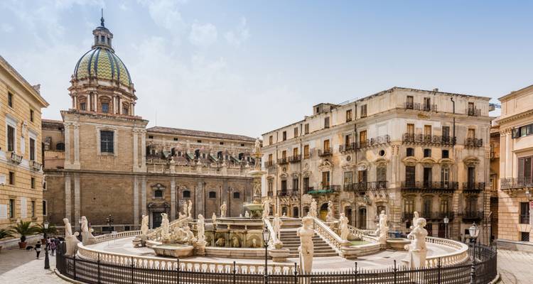 Plan large de la Fontana Pretoria ornée de Palerme avec les bâtiments baroques environnants sous un ciel bleu.