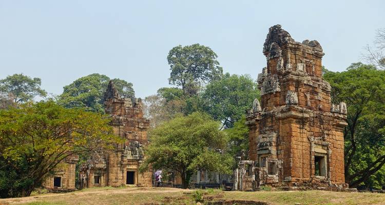 Alte Backsteintempeeltürme erheben sich zwischen Bäumen im archäologischen Park von Angkor.