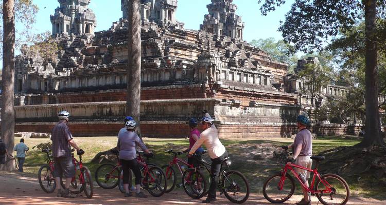 Groupe de cyclistes près des ruines d'un ancien temple.