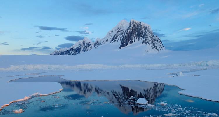 Montagne enneigée se reflétant dans l'eau glacée