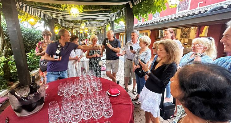 Groupe de personnes participant à un événement de dégustation de vin en plein air.