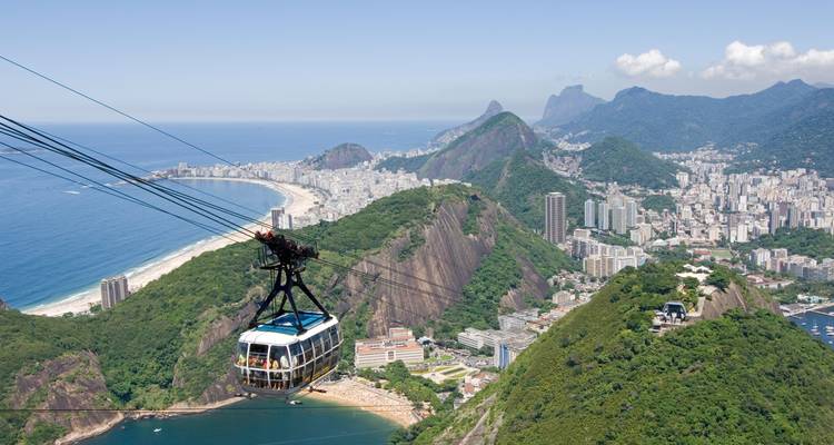 Un teleférico con vistas a una ciudad y a la costa.