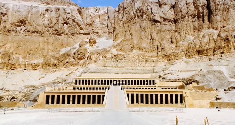 El monumental Templo Funerario de Hatshepsut con sus columnas se alza dramáticamente contra los acantilados de piedra caliza.
