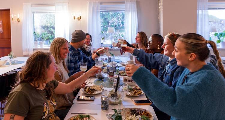 Groupe de personnes dînant et levant leurs verres pour porter un toast.