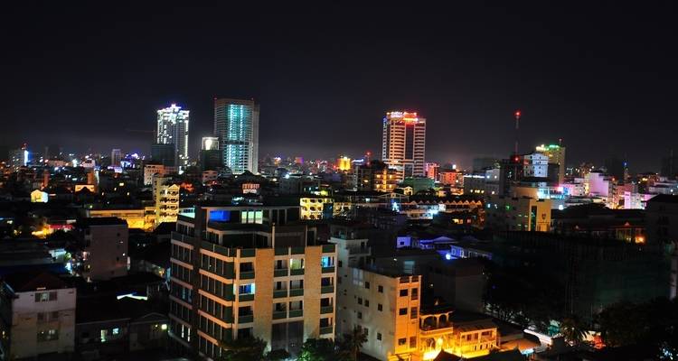 Paysage urbain nocturne avec des lumières vives de la ville et des bâtiments.