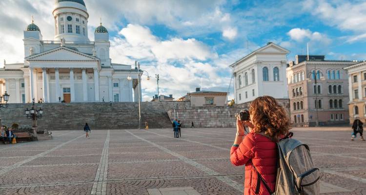 A person photographing the Helsinki Cathedral during the day.
