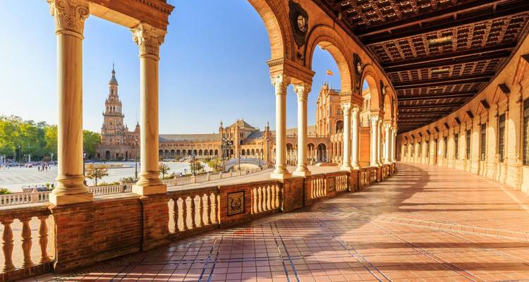 Wijd uitzicht op Plaza de España met bogen en torens in Sevilla.
