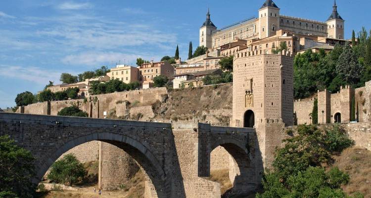 Pont historique sur fond de ville à flanc de colline.