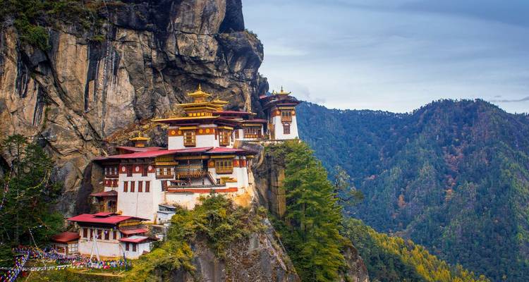 Ikonisches Klosterkloster an der Klippe, umgeben von bewaldeten Bergen.