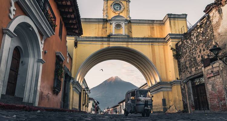 Arco colonial con un volcán al fondo.