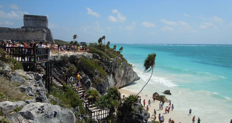 Crowds exploring cliff-top Mayan ruins overlooking the turquoise Caribbean at Tulum