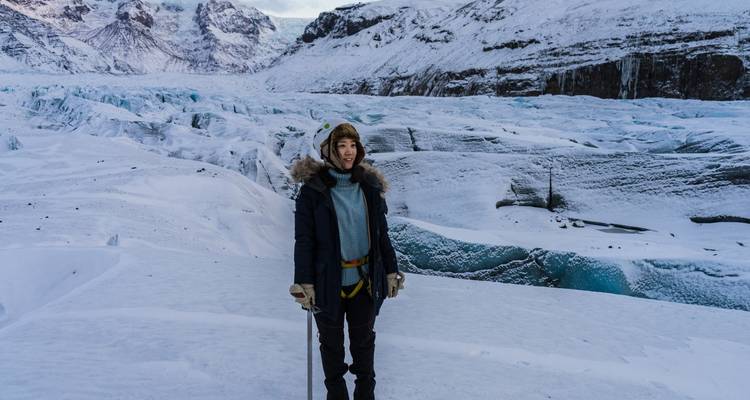 Personne debout sur un paysage de glacier enneigé.
