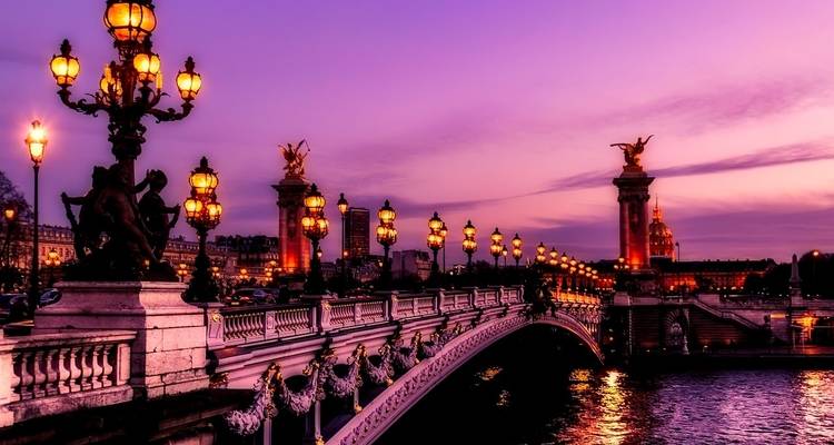 Pont Alexandre III Brücke in Paris in der Abenddämmerung mit verzierten Laternenmasten.
