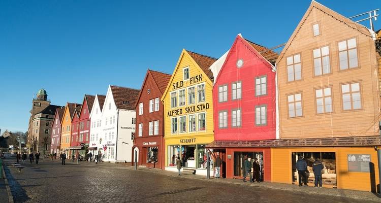 Bâtiments en bois colorés sur une rue pavée.
