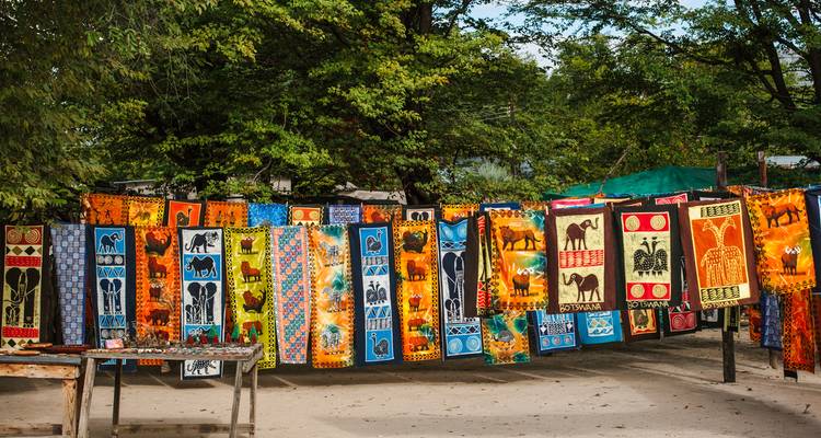Marché local coloré avec des textiles vibrants suspendus en vitrine.