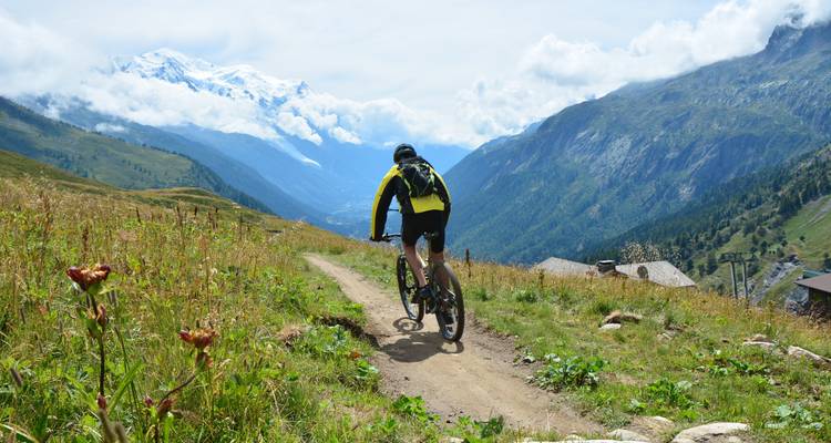 Cycliste sur un sentier de montagne avec des vues panoramiques.