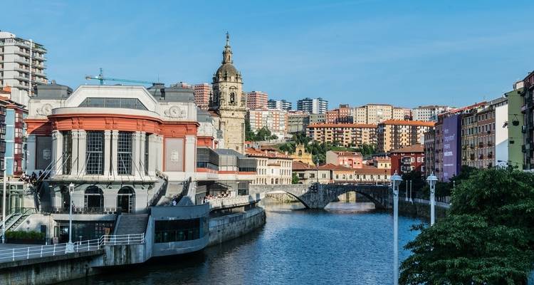Paisaje urbano de Bilbao con río y edificios.