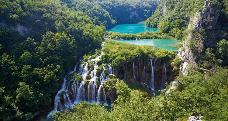 Waterfalls cascading into turquoise lakes surrounded by lush greenery.