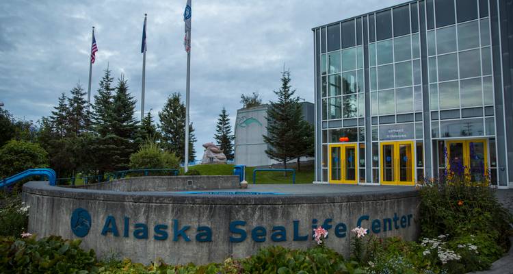 Exterior of Alaska SeaLife Center with glass facade and signage on an overcast day