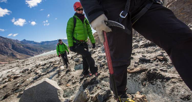 Les randonneurs sur glace équipés de crampons et de piolets naviguant sur un terrain glaciaire sous un ciel dégagé
