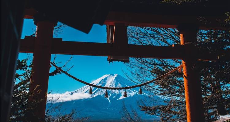 Schneebedeckter Berg Fuji, gerahmt von einem Torii-Tor am Seeufer und blauem Winterhimmel